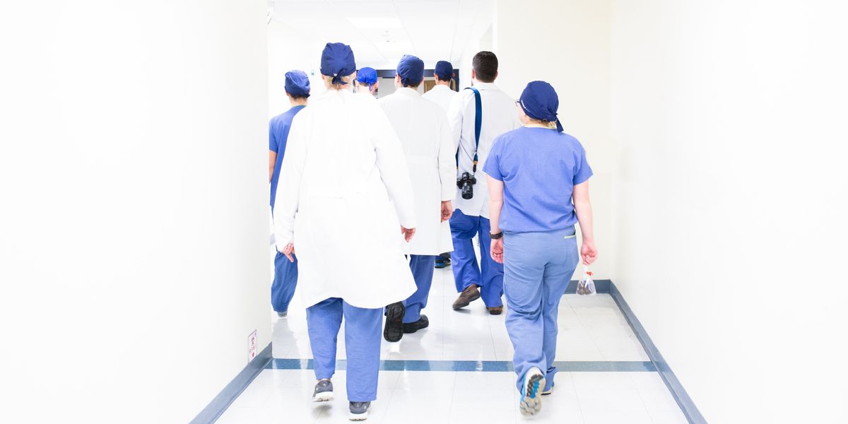 Doctors in medical scrubs walking down a hallway.