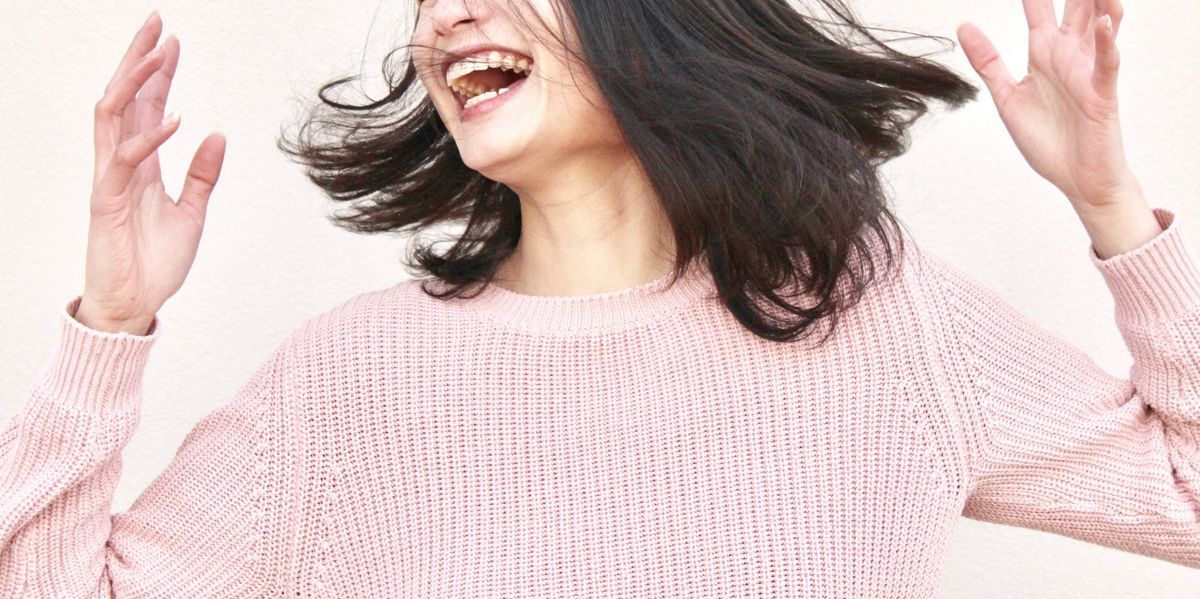 laughing woman wearing pink sweater