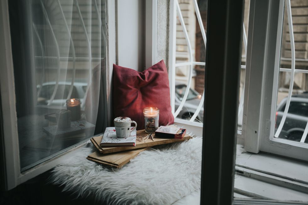 pillows, books and candle on a window seat