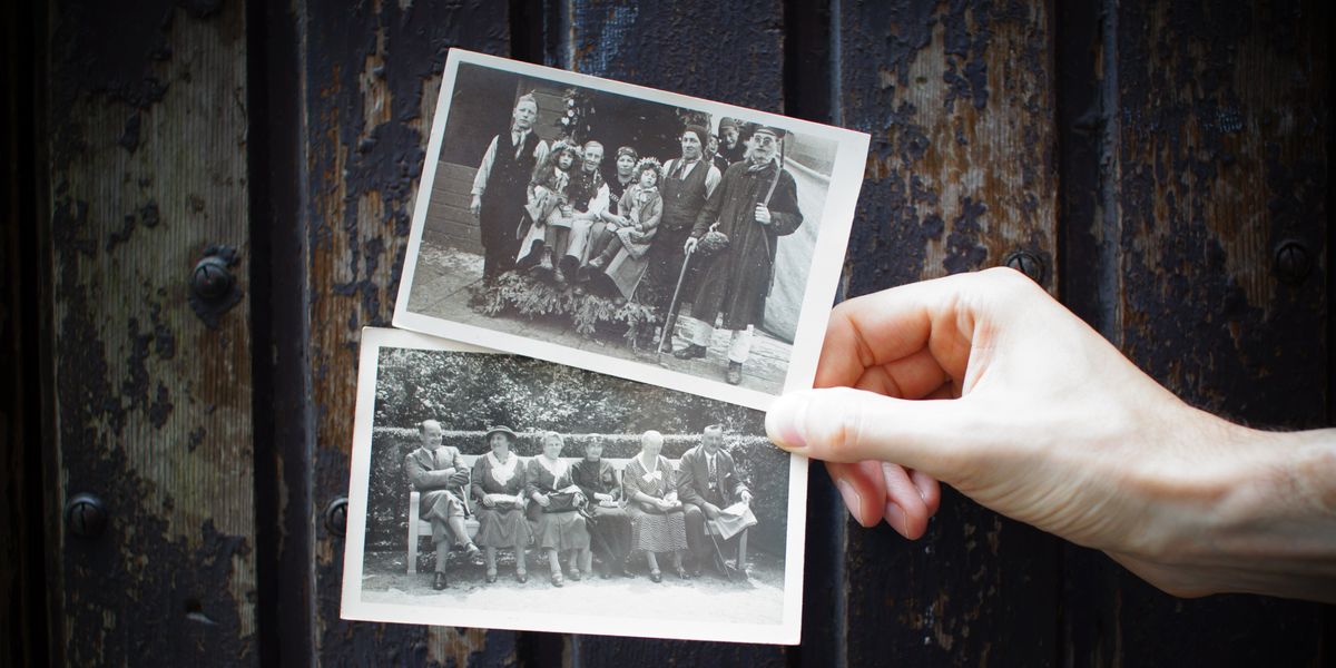 Person holding two vintage photographs of family portraits