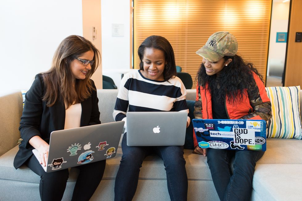 three-women-sitting-on-sofa-with-MacBook-networking
