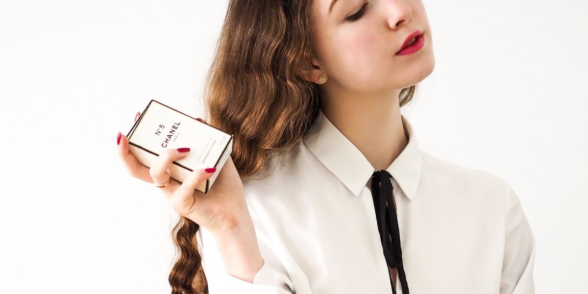 Aloof teen with high-end clothes and bottle of Chanel