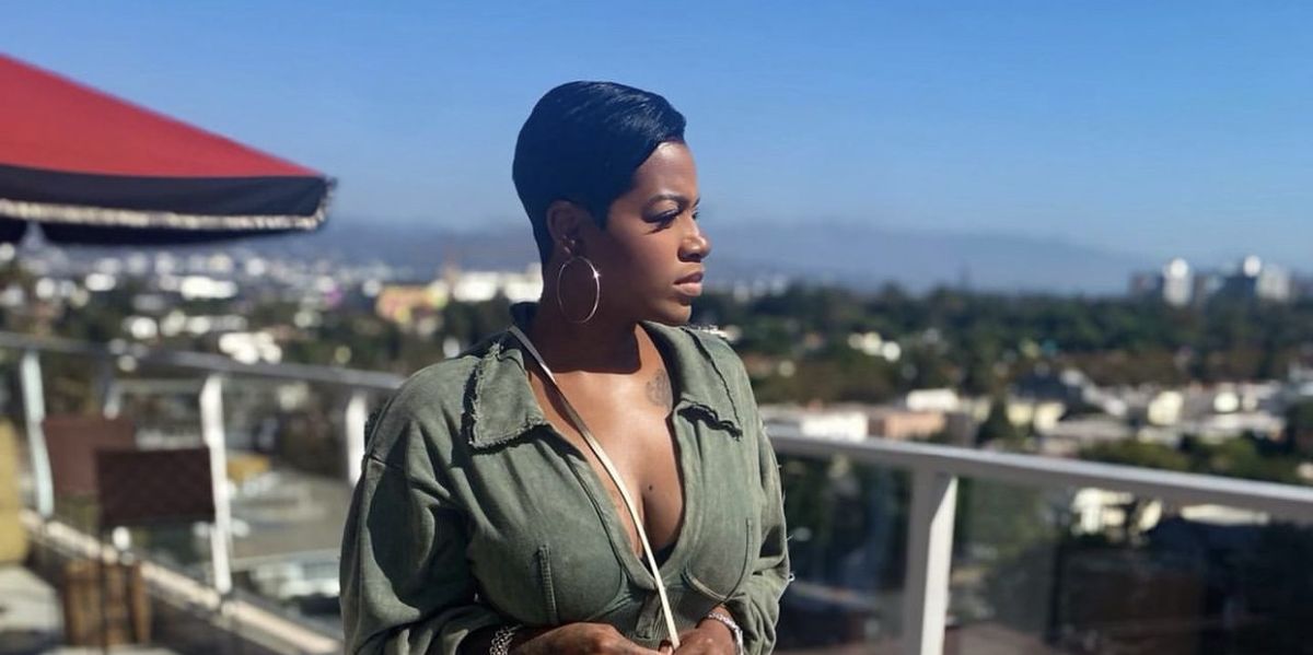 Singer-actress-Fantasia-wearing-olive-green-outfit-looking-off-to-the-side-as-she-poses-on-balcony