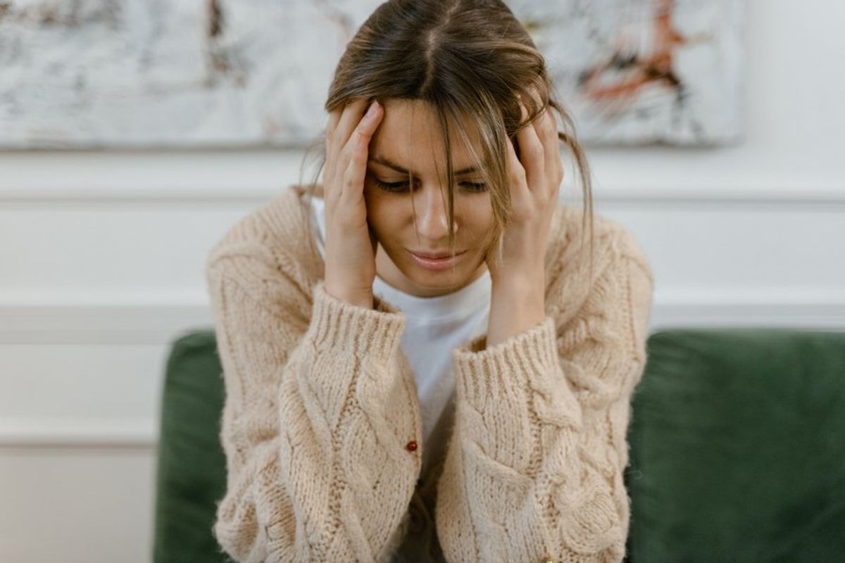 woman holding her head in her hands