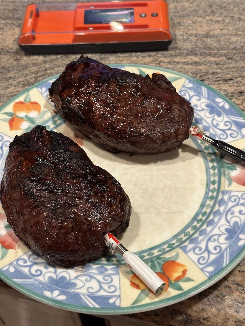 a photo of ThermoPro Twin TempSpike Smart Meat Thermometers inserted in two steaks on a plate