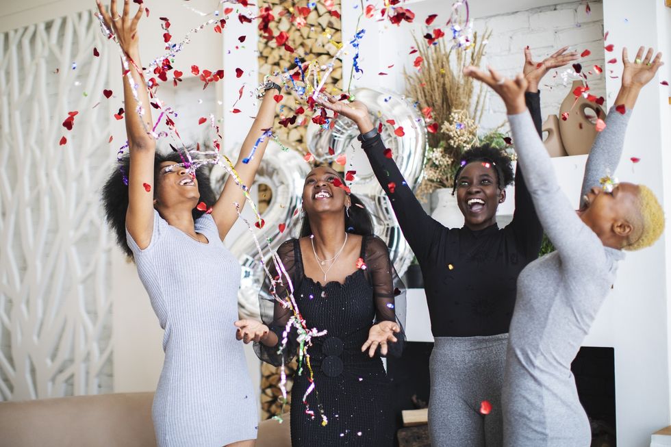 a-group-of-four-women-embracing-holiday-cheer-with-confetti