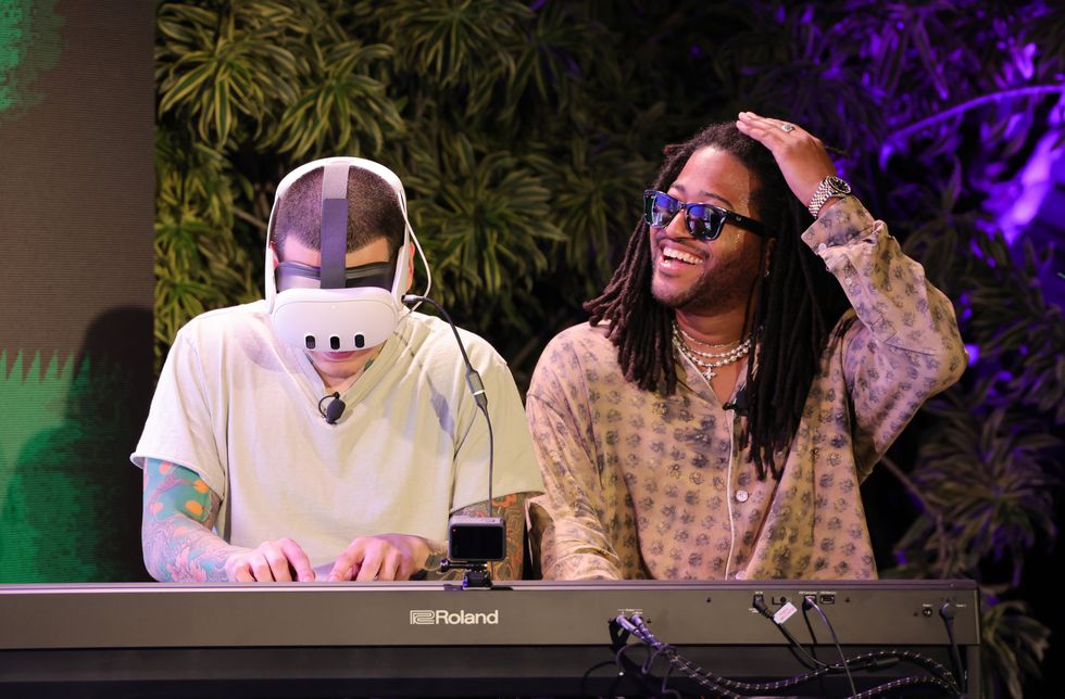 two men sitting at a piano, one wearing a MetaQuest headset
