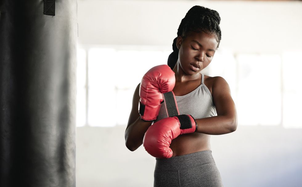 Young-woman-training-exercise-preparing-boxing-gloves-in-boxing-gym