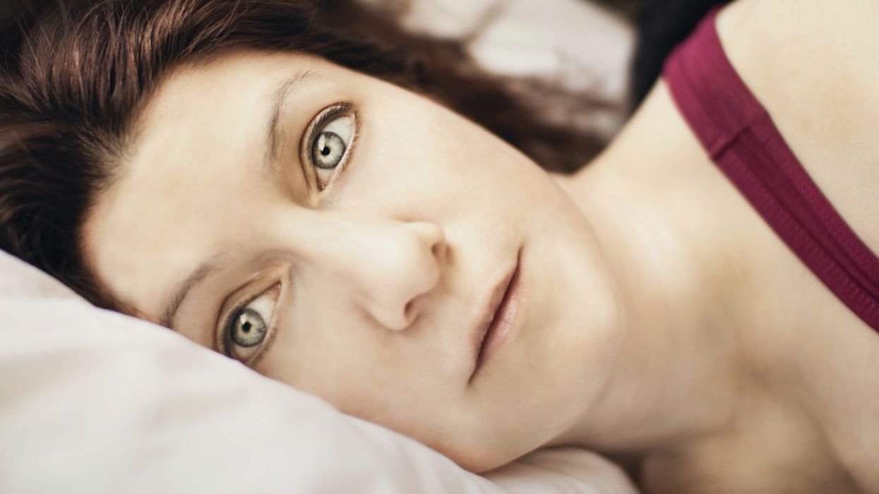 Close up face of a woman in bed, staring into the camera