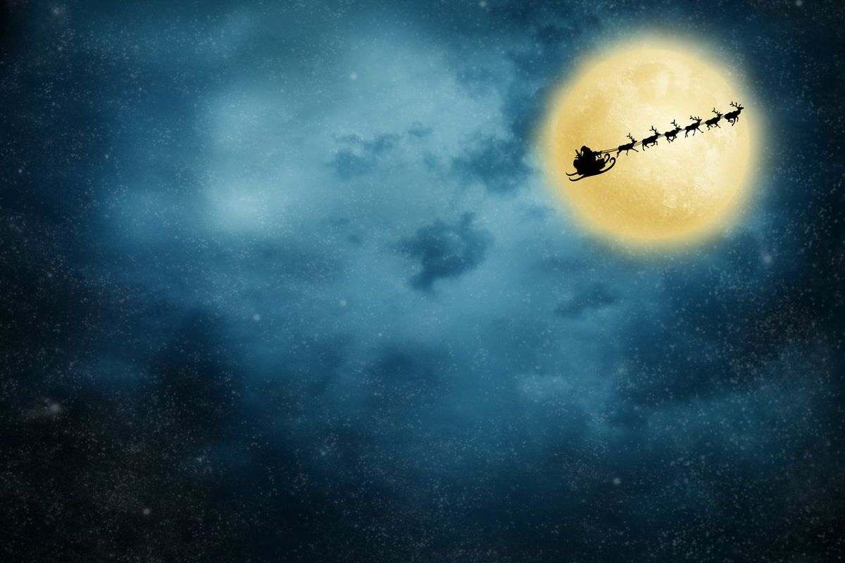 a photo of Santa Claus and his reindeer flying with the moon in the background