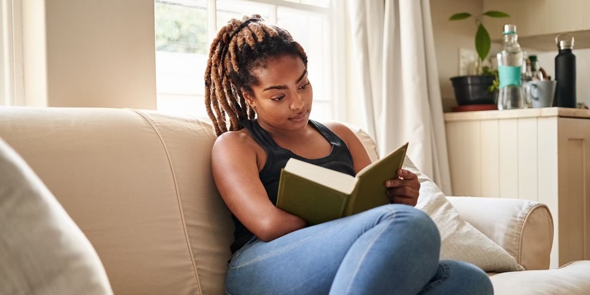 young-woman-sitting-on-the-couch-reading-a-book