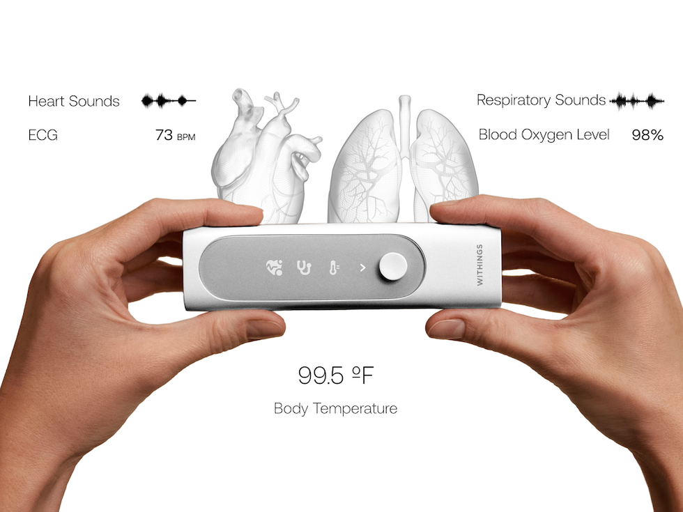 a photo of two hands holdiing a Withings BeamO device