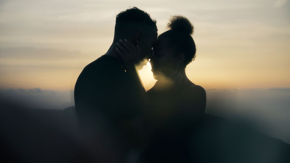 silhouette-of-a-couple-embracing-with-sun-setting-in-background