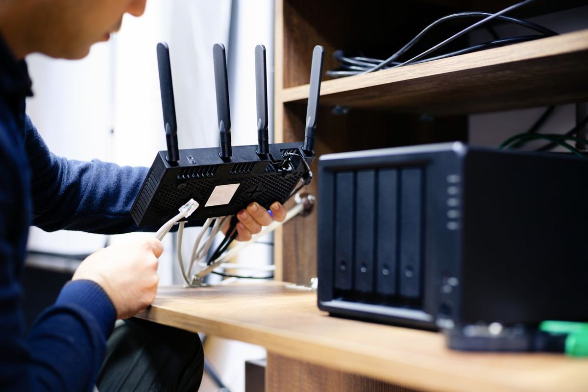 A man setting up a router in a home.