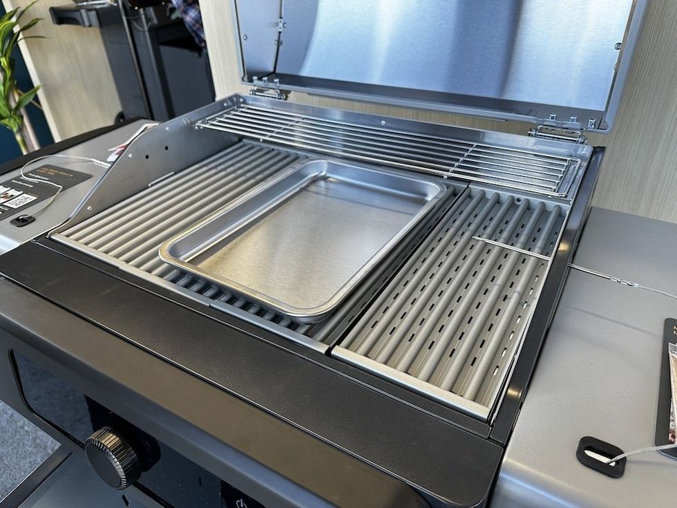 a photo of Current Model G Dual-Zone Electric Grill opened and pan on the grill for woodchips.