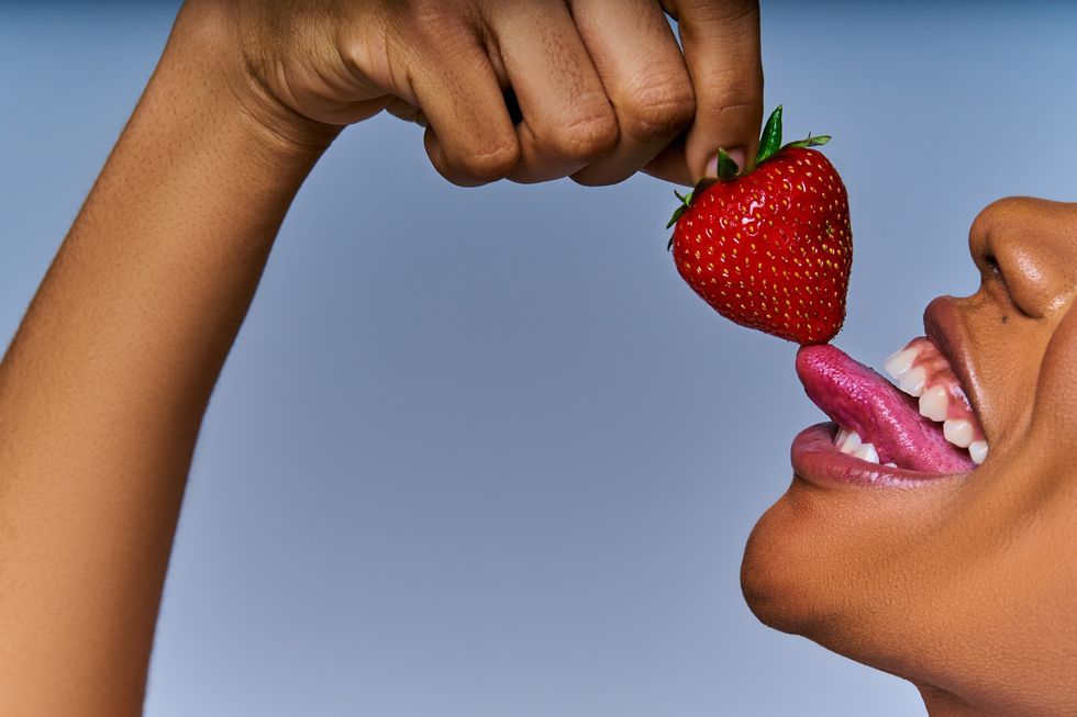 woman-with-her-tongue-out-to-lick-a-strawberry