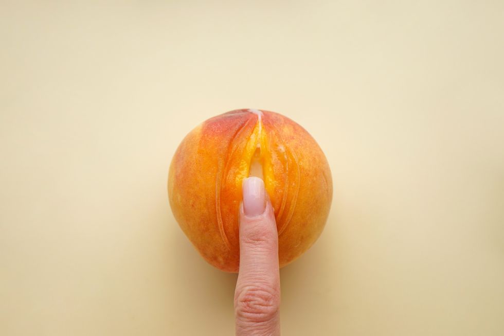 Woman-s-finger-pressing-the-slit-of-a-sliced-open-peach