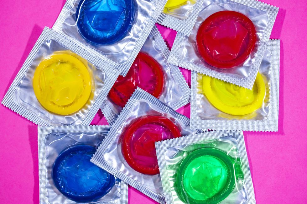 Multi-colored-condoms-on-neon-pink-background
