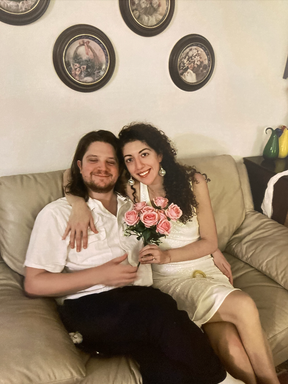 man and woman in wedding clothes sitting on a sofa