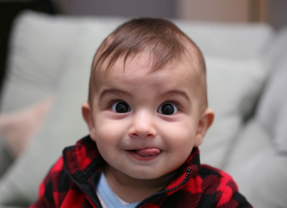 A baby sticks his tongue out