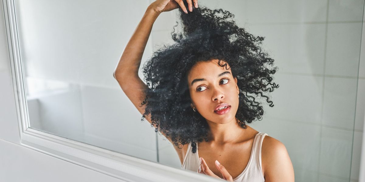 Black-woman-examining-her-hair-in-the-mirror