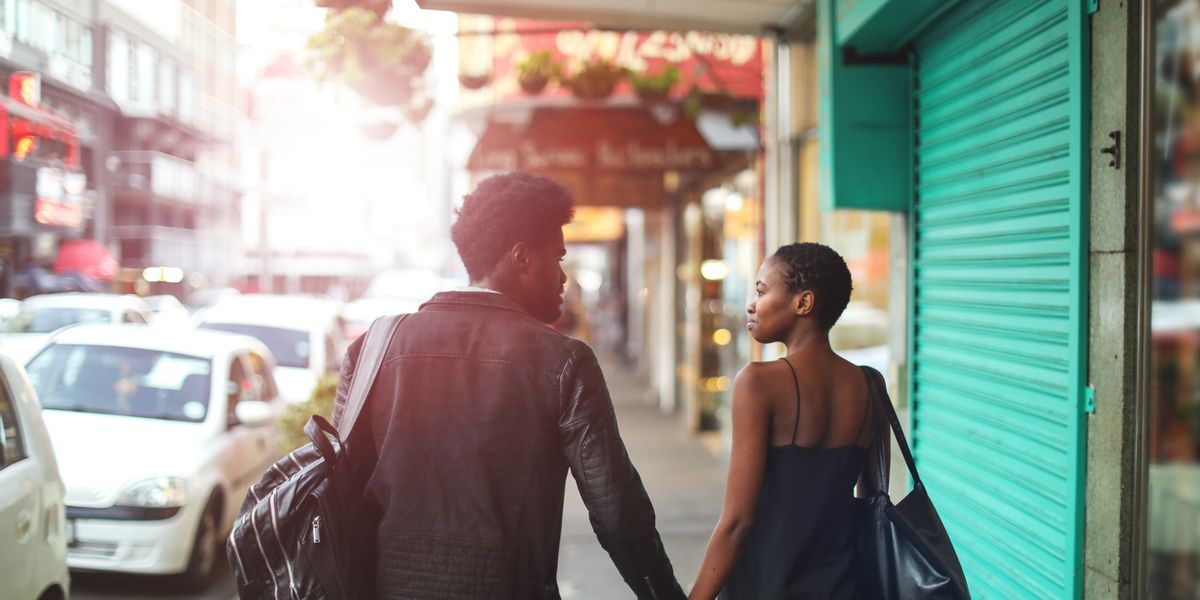Black couple holding hands while walking down the street