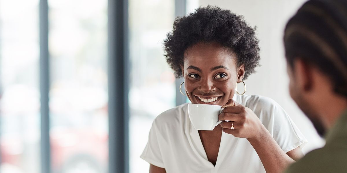 Black-woman-smiling-while-enjoying-a-coffee-date