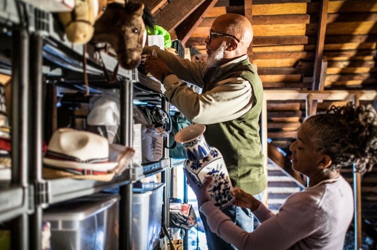 man and woman in an attic full of stuff