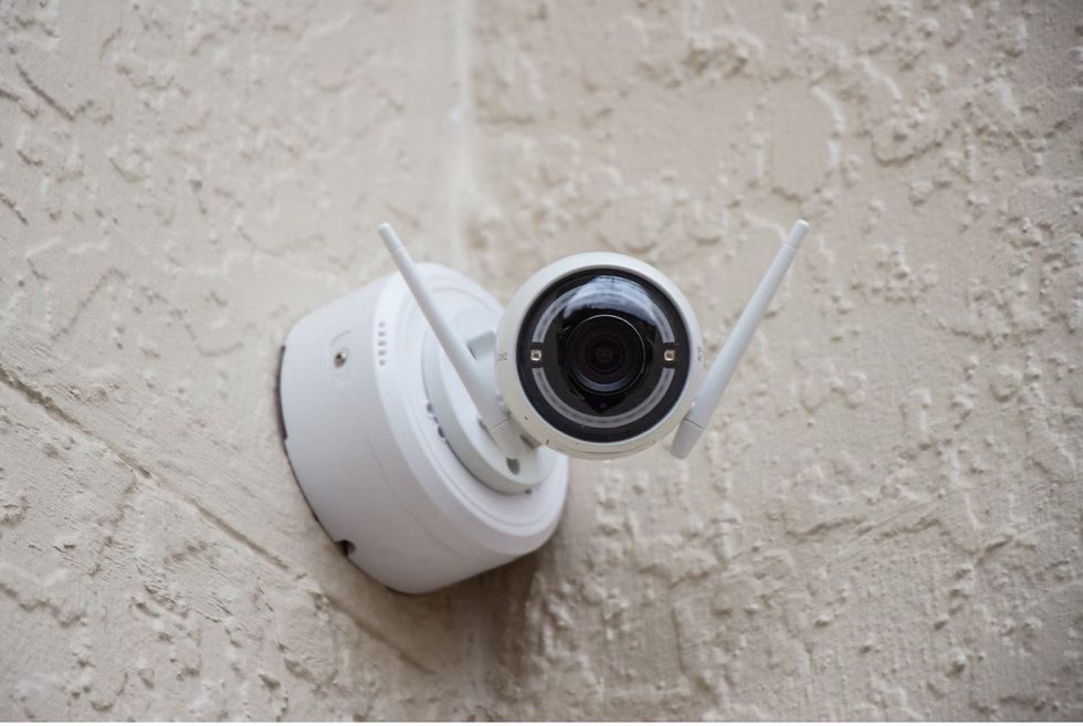 a photo of a smart home security camera installed on the outside of a home.