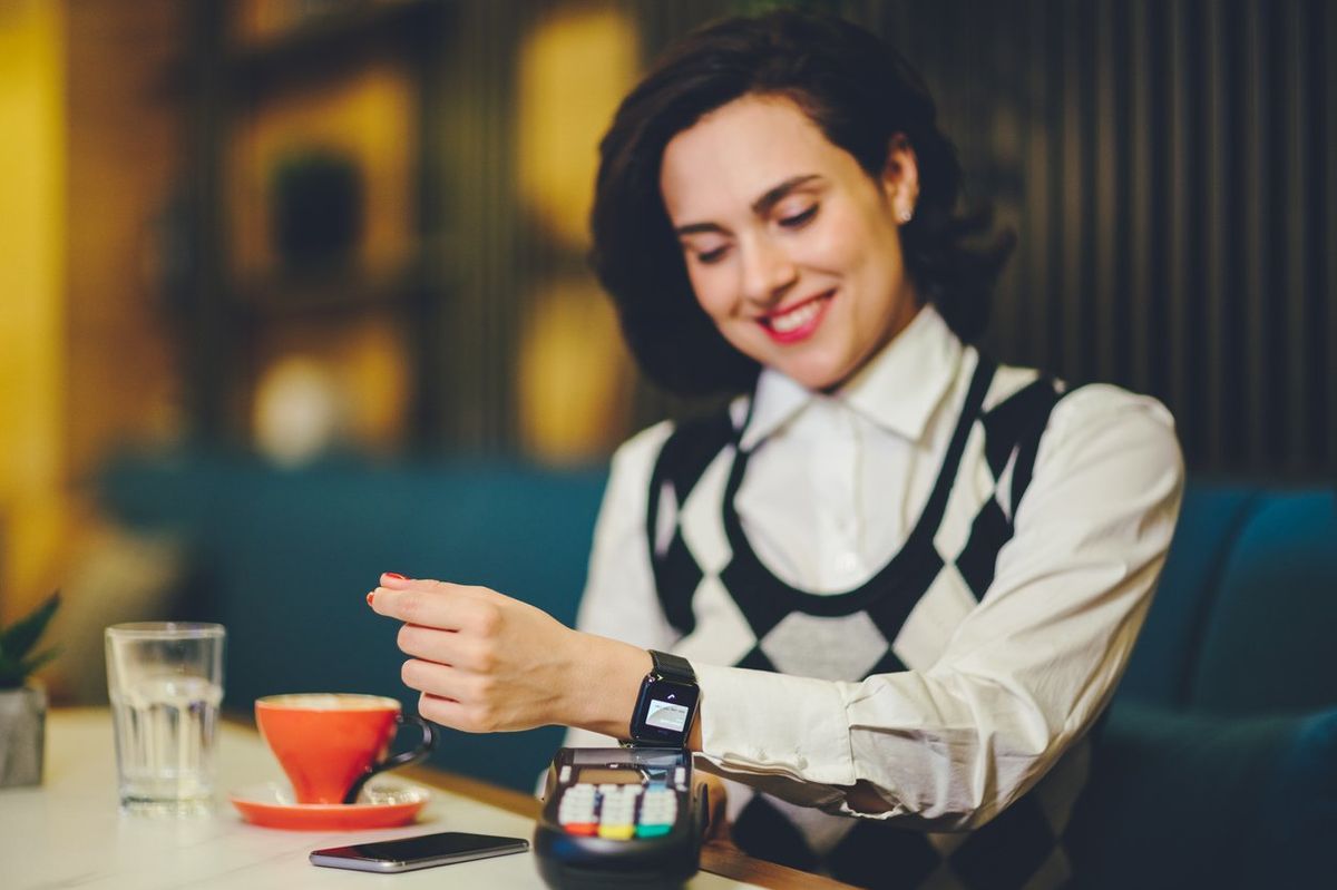 a woman using her smartwatch to pay
