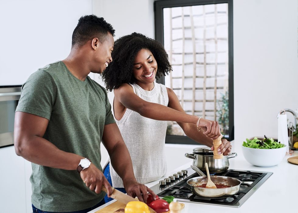 Cheerful-young-man-and-woman-cooking-together-in-the-kitchen
