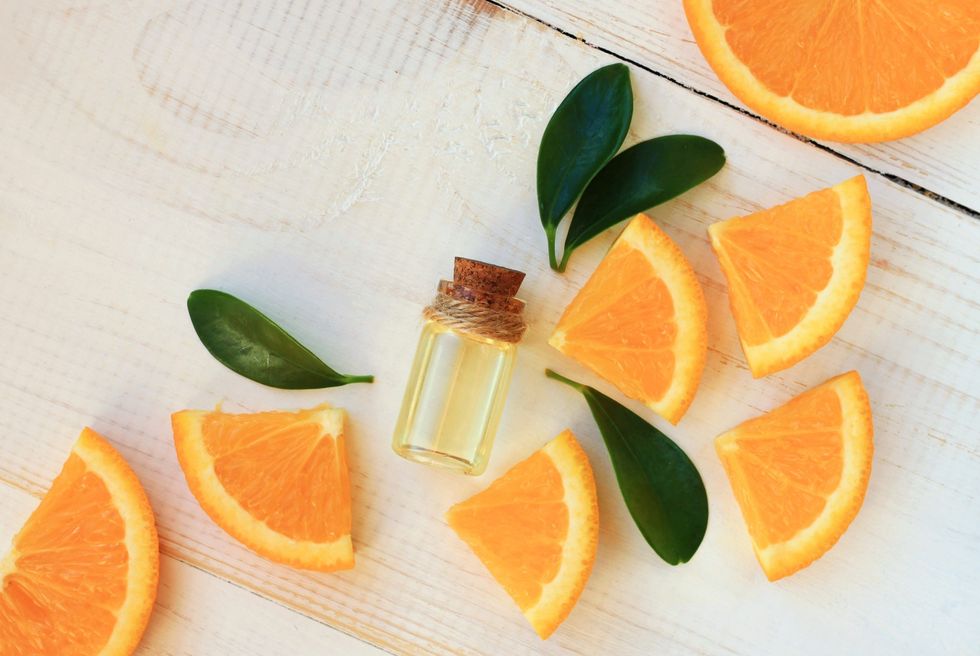 Orange-slices-around-small-bottle-of-citrus-oil
