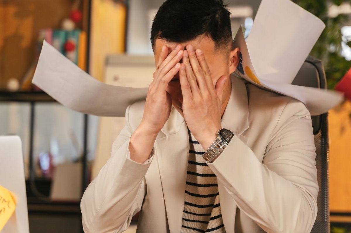 man in an office with his head in his hands