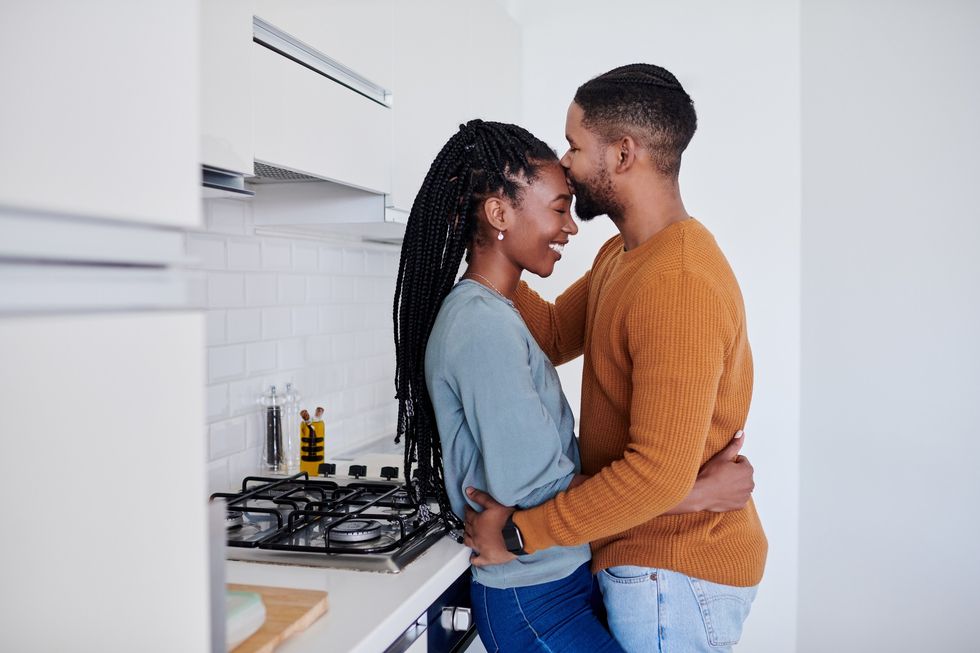 Black couple cozied up in the kitchen.
