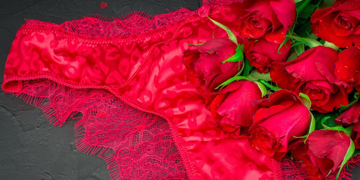 Red-lace-panties-and-bouquet-of-red-roses-against-black-background