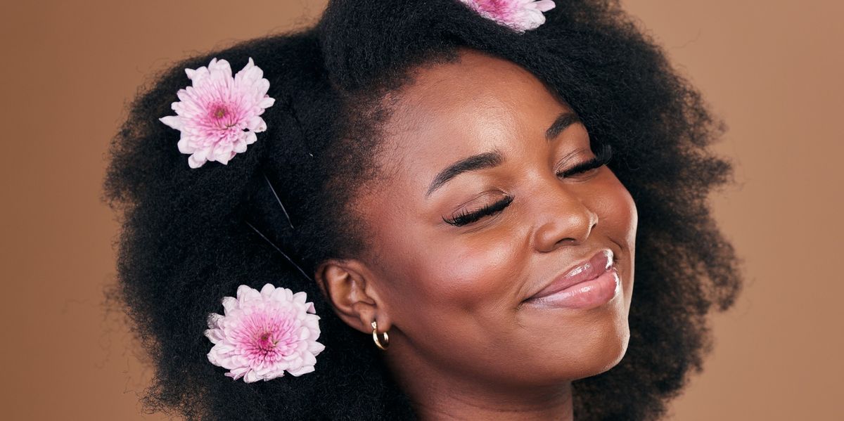 Smiling-woman-with-her-eyes-closed-flowers-in-her-afro-hair