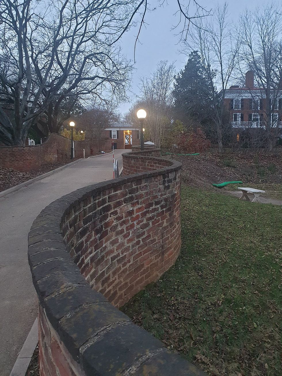 wavy brick wall separating a grassy area and a driveway