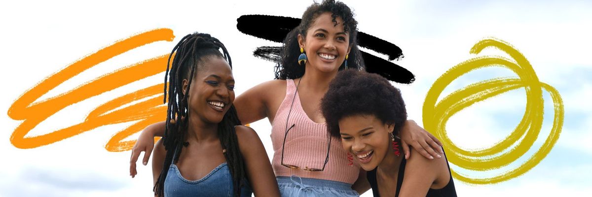 Three joyful Afro-Latina women sharing smiles on a bright and sunny day.
