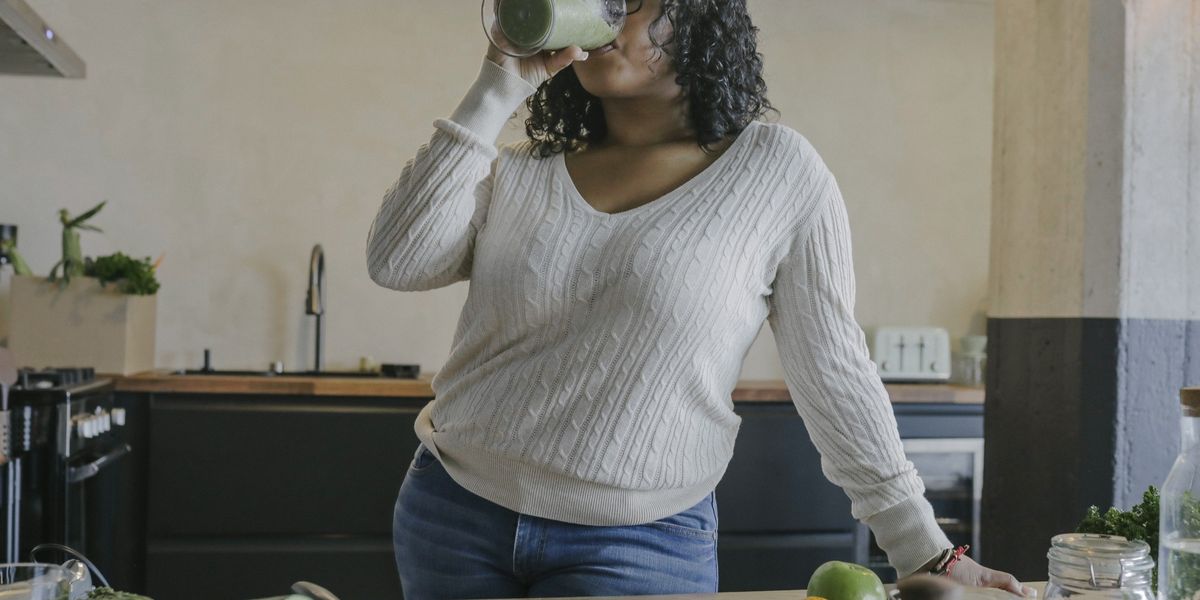 Young-woman-enjoying-delicious-healthy-smoothie-in-her-kitchen