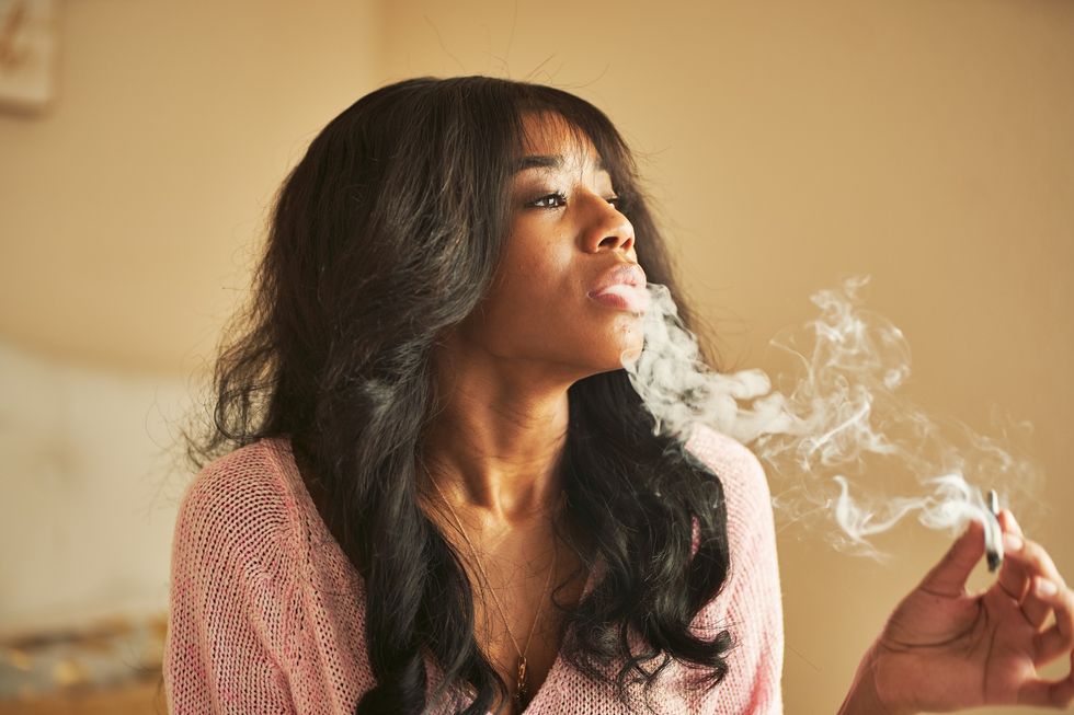 Black-woman-enjoying-a-smoke-in-her-bedroom