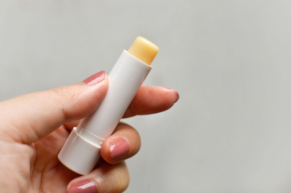 Manicured-hand-holding-tube-of-lip-balm