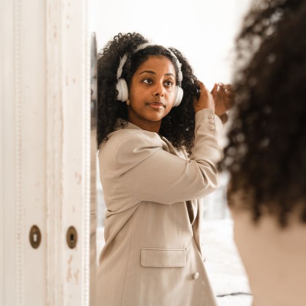 Young-professional-fixing-her-hair-in-the-mirror-as-she-gets-ready-for-work