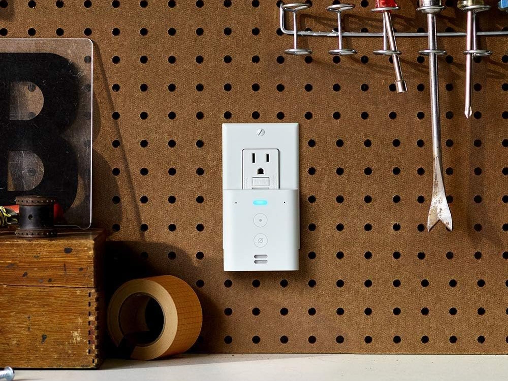 a photo of Amazon Echo Flex smart speaker plug plugged into a socket on a workbench.