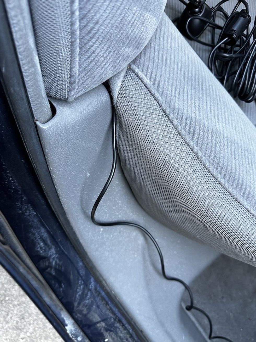 a photo of the Nextbase power cable being tucked behind the seats in a car