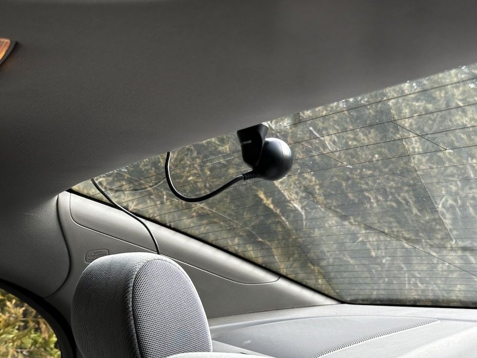 a photo of the Nextbase Rear Window Camera installed on a car with cable exposed