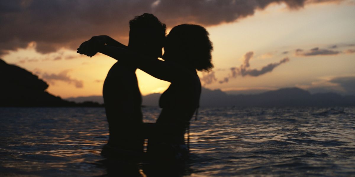 Silhouette-of-Black-couple-having-intimate-moment-in-the-ocean-at-the-beach