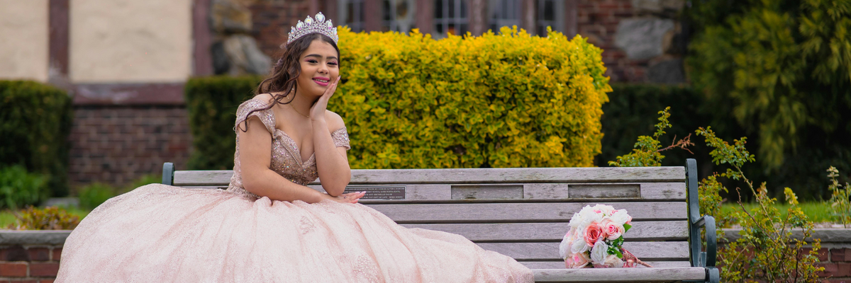 A Latina teenager poses for a photo wearing her quinceanera dress