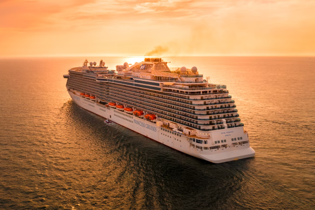 a cruise ship on the ocean at sunset