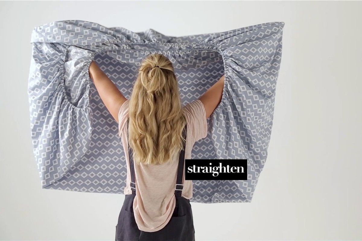 woman folding a fitted sheet