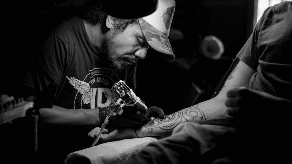 tatto artist administering a tattoo